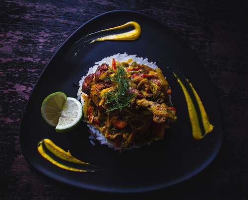 food cooked food served on black plate citrus fruit