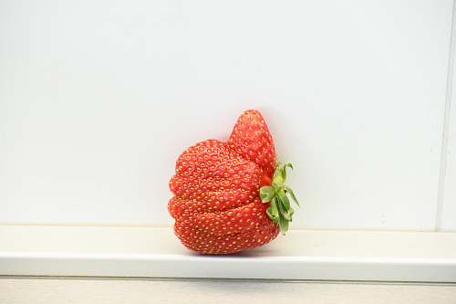 food red strawberry on white surface plant