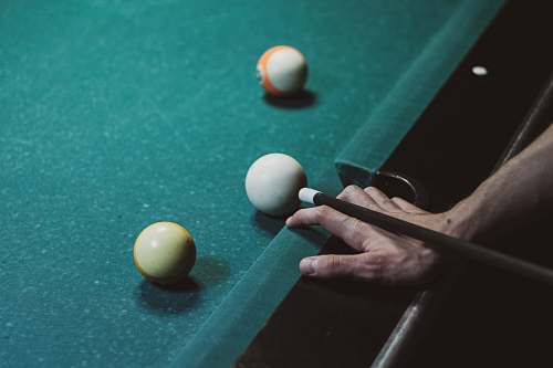 indoors three white, yellow, and orange cue balls room