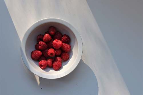 fruit red raspberries on white ceramic bowl raspberry
