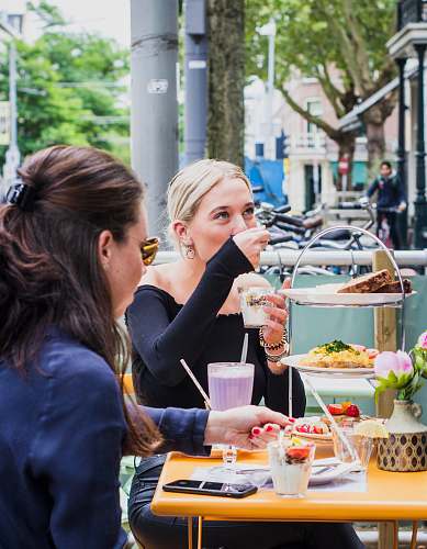 food 2 women sitting in front of table meal