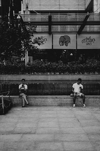 black-and-white grayscale photography of man and woman siting clothing