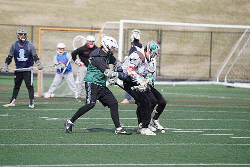 clothing lacrosse players playing on field under white sky human