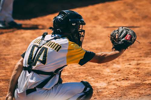 clothing man sitting and about to catch ball helmet