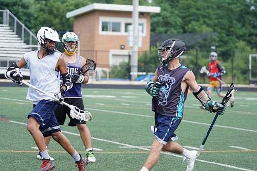 clothing man wearing white tank top and blue gym short holding lacrosse stick helmet