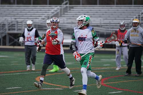 person men playing lacrosse during daytime human