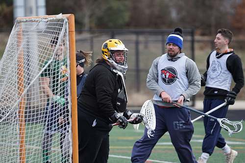 clothing people playing lacrosse during daytime helmet