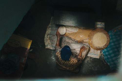 clothing person sitting beside mat with flat dough on wooden panel sport