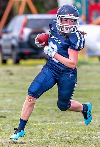 clothing woman in blue football jersey holding football helmet