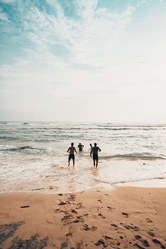 ocean men running toward beach coast