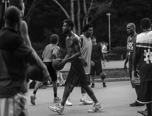 people grayscale photo of people playing basketball person