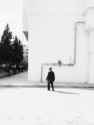 human man walking towards curb and building person