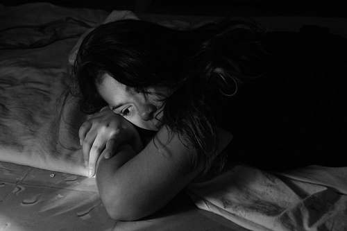 black woman leaning on bed woman