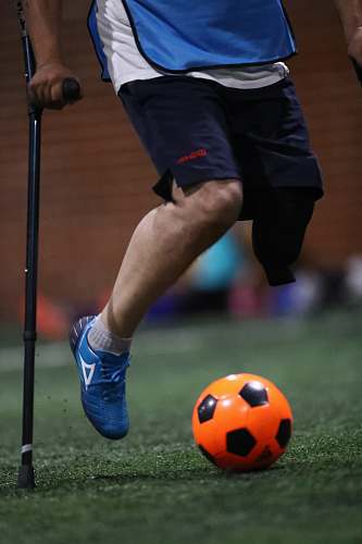 shoe person using black cane playing soccer on field footwear