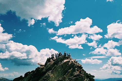 blue people on rock formation under white cloudy sky sky