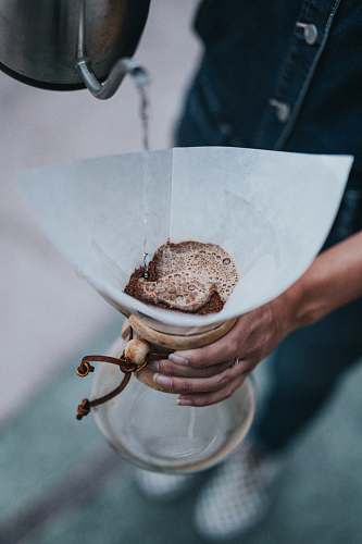 brew person holding clear glass pitcher pour