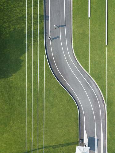 sports aerial photography of two person running on road during daytime sport