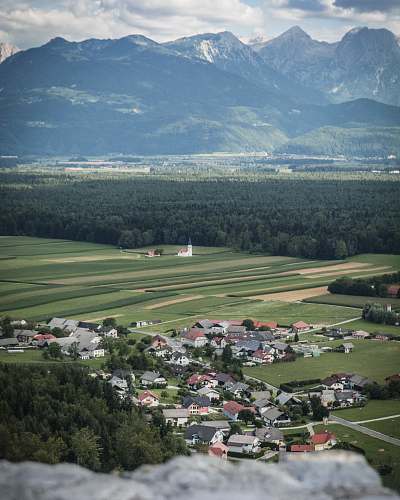 outdoors high-angle photo of establishment in front of mountain grassland