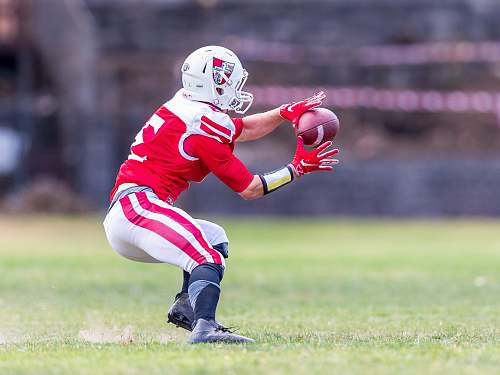 apparel man catching football ball on green field clothing