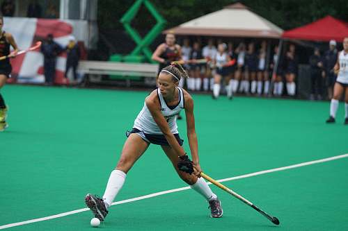 human woman holding hockey stick on field people