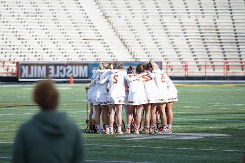 person all women lacrosse team on huddle at the field apparel