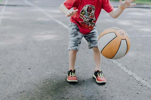 person boy playing ball at daytime sphere