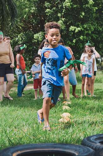 person boy running on green lawn tire