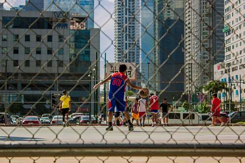 person boys playing basketball on outdoor court during daytime automobile