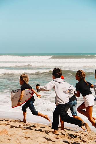 person children running on seashore across horizon nature