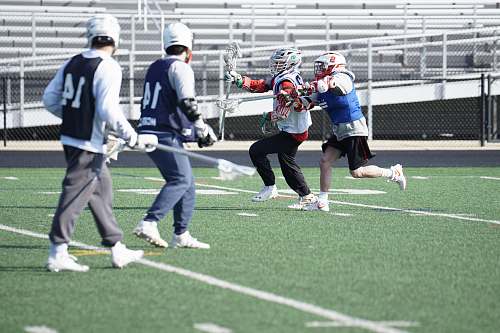 person four men playing lacrosse apparel