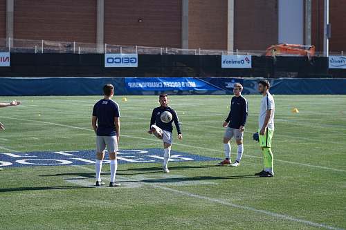 person four person playing soccer on field during daytime people