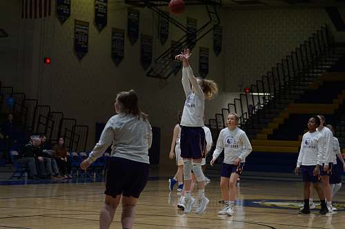 person girl playing basketball inside court apparel
