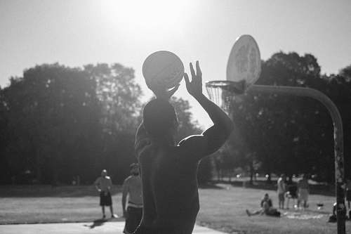 person grayscale photo of man playing basketball black-and-white