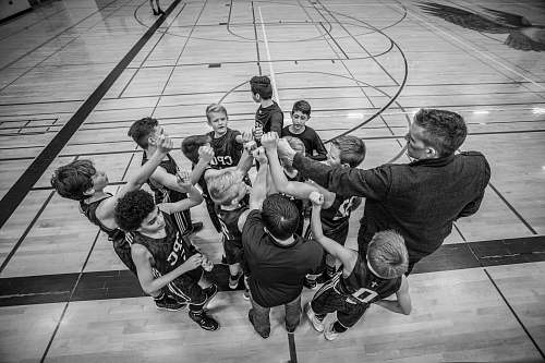 person grayscale photography of boys raising hand black-and-white