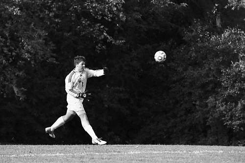 person grayscale photography of man playing soccer black-and-white