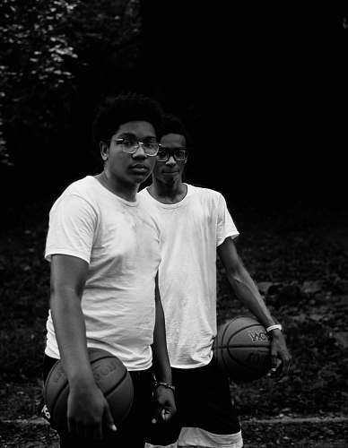 person grayscale photography of two man in shirts holding basketball black-and-white
