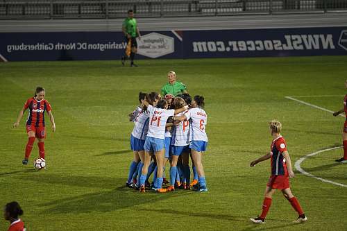 person group of soccer player hugging soccer