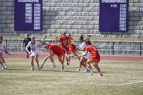 person group of woman playing lacrosse during daytime people