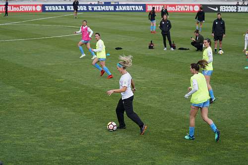 person group on women playing soccer on soccer field during daytime people