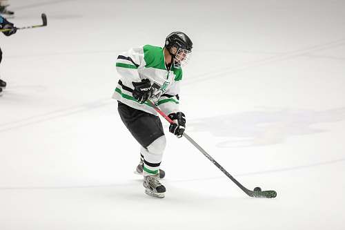 person hockey player in green and white jersey apparel