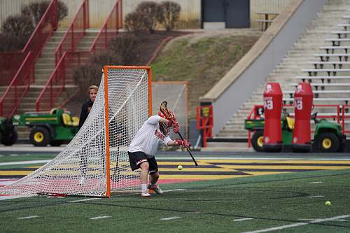 hockey lacrosse goalie defending goal on field at daytime people
