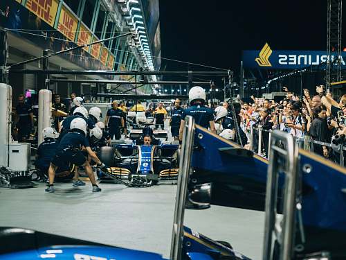 person man driving F1 car during nighttime people