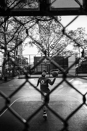 person man holding ball through ring\ black-and-white