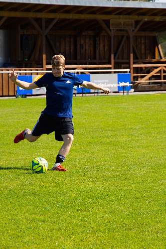 people man kicking soccer ball person