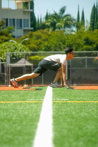 people man on grass getting ready to run during day person
