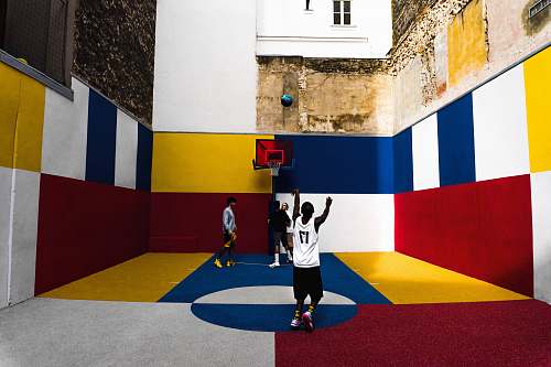 person man playing basketball inside multicolored court people