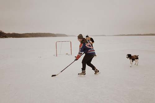 person man playing ice hockey dog