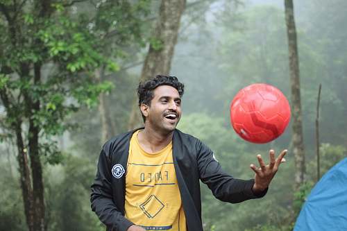 person man playing red soccer ball sphere
