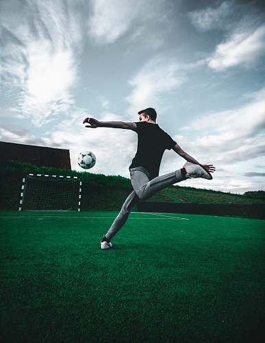person man playing soccer during daytime people