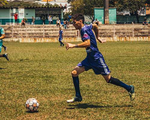 person man playing soccer on field people